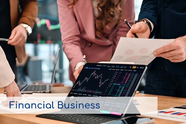 Equipo de trabajo analizando gráficos financieros en una tablet, representando los servicios de Negocios Financieros.