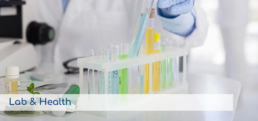 Profesional de laboratorio analizando muestras en tubos de ensayo, representando los servicios de Laboratorio y Salud.