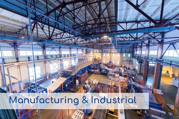 Interior de una planta de fabricación con maquinaria, representando los servicios de Manufactura e Industria.