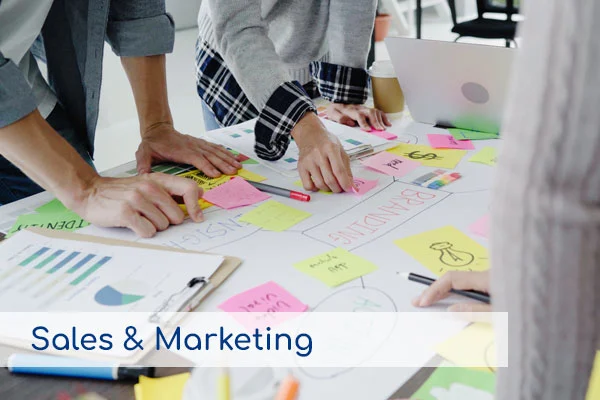 Personas trabajando con notas adhesivas sobre estrategias de branding, representando los servicios de Ventas y Marketing.
