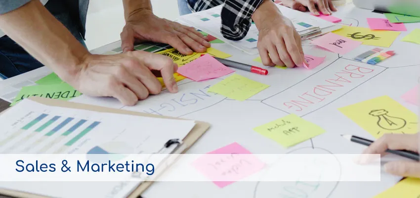 Personas trabajando con notas adhesivas sobre estrategias de branding, representando los servicios de Ventas y Marketing.