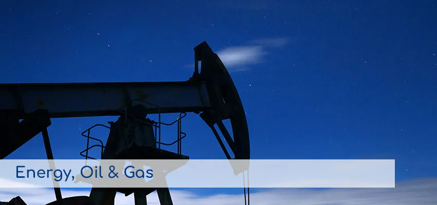 Torre de extracción de petróleo bajo un cielo nocturno, representando los servicios de Energía, Petróleo y Gas.