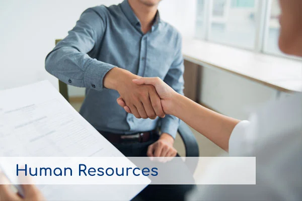 Dos personas dándose la mano en una entrevista de trabajo, representando los servicios de Recursos Humanos.