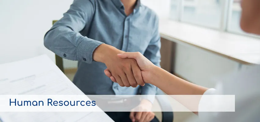 Dos personas dándose la mano en una entrevista de trabajo, representando los servicios de Recursos Humanos.